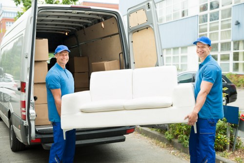 Local movers carrying furniture through a Maida Vale residential building